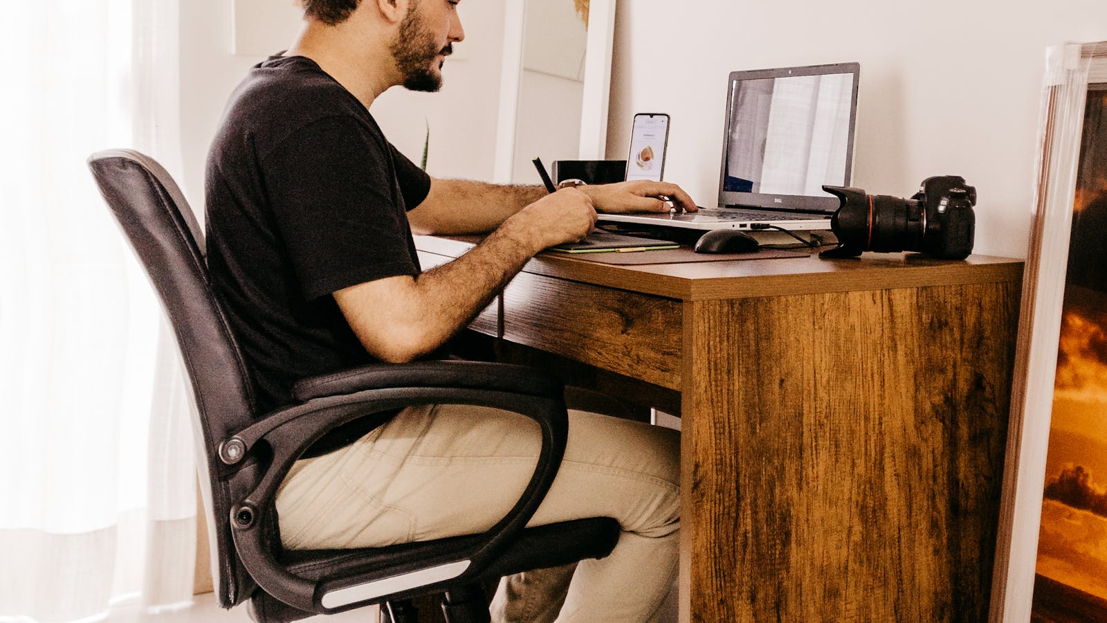 Self-employed professional working at a home office desk with a laptop